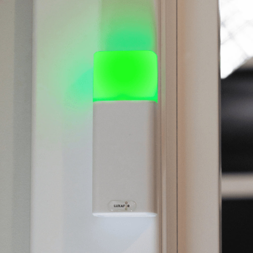 Luxafor Bluetooth Pro Busylight hvid lyser grønt på mur ved mødelokale